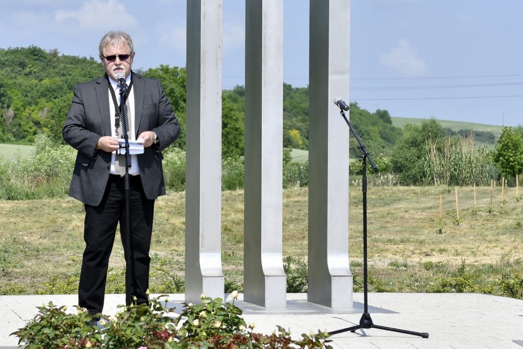 Féhr György, a Paksi Német Nemzetiségi Önkormányzat elnöke beszédet mond a kitelepítési emlékműnél Dunakömlődön. Fotó: Szaffenauer Ferenc/Paksi Hírnök