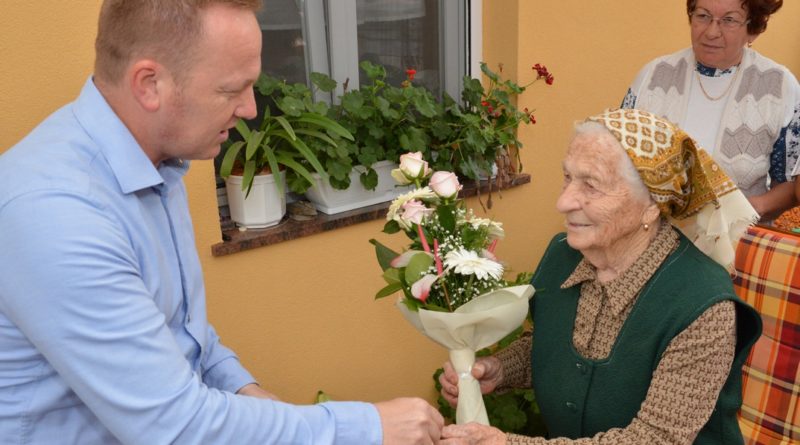 A 95 esztendős Binder Erzsébetet köszönti Szabó Péter Paks alpolgármestere. Fotó: Szaffenauer Ferenc/Paksi Hírnök