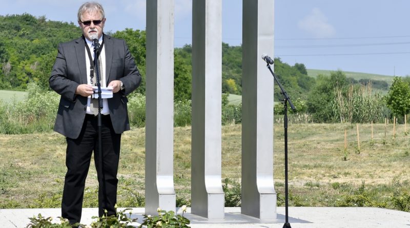 Féhr György, a Paksi Német Nemzetiségi Önkormányzat elnöke beszédet mond a kitelepítési emlékműnél Dunakömlődön. Fotó: Szaffenauer Ferenc/Paksi Hírnök